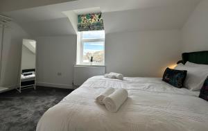 a bedroom with a white bed with towels on it at Clock Tower Apartment No4 in Morecambe
