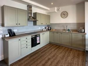 a kitchen with white cabinets and a sink at Clock Tower Apartment No4 in Morecambe