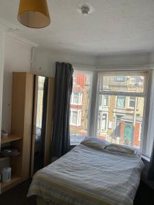 a bedroom with a bed and a large window at MyRoomz Golden Strand Hotel in Blackpool