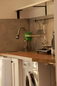 a kitchen with a sink and a washing machine at DeBoskie Domki in Mrągowo