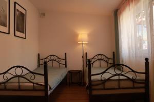 two beds in a room with a lamp and a window at DeBoskie Domki in Mrągowo