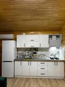 a kitchen with white cabinets and a wooden ceiling at Adrasan yeşim apart evleri in Kumluca