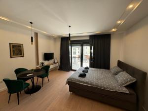 a bedroom with a bed and a table and chairs at Epicenter Suite in Trebinje