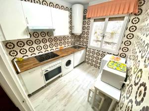 a small kitchen with white appliances and a table at La pepa marinera in Lastres