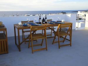 a wooden table with bottles of wine and chairs at Pool House in La Santa