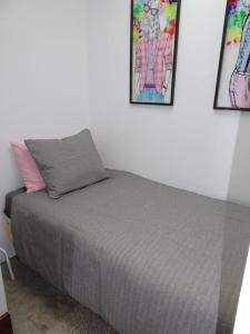 a bed in a room with two pictures on the wall at Pool House in La Santa