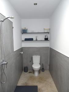 a small bathroom with a toilet and a shower at Pool House in La Santa +17 photos