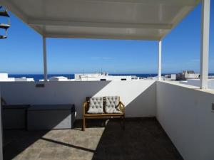 a chair on a balcony with a view of the city at Pool House in La Santa