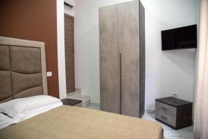 a bedroom with a bed and a cabinet with a television at Casa Vacanze - Bovalino in Bovalino Marina