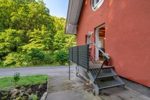 a red house with a staircase leading to a door at Ferienwohnung am Hirschfelsen in Bühlertal