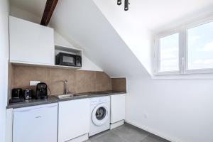 a white laundry room with a washer and dryer at Studio confortable Anciennes écuries réhabilitée in Issy-les-Moulineaux