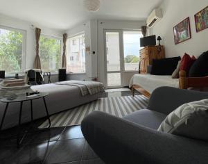 een slaapkamer met een bed, een bank en een tafel bij Modern flat near downtown Plovdiv in Plovdiv