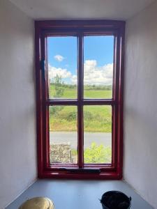 una finestra rossa in una stanza con vista di The Old Mill, Kilcorkey Bellanagare, Castlerea, County Roscommon - West of Ireland - House 2 a Bellanagare