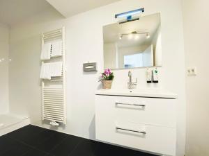 Un baño blanco con lavabo y espejo. en Victoria Apartments, en Düsseldorf 52 fotos más