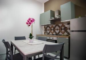 a kitchen with a table with a vase of flowers on it at Casa Vacanze - Bovalino in Bovalino Marina