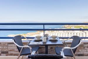 a table and chairs on a balcony with a view of the ocean at Luxuriöse Wohnung mit Meerblick in Playa Paraiso in Adeje