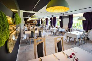 ein Restaurant mit weißen Tischen und Stühlen und lila Vorhängen in der Unterkunft Hotel Boginia in Boginia