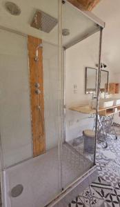 a shower stall in a room with a table at LE NID Appt 2 chambres Proche Pont du Gard in Remoulins +23 photos