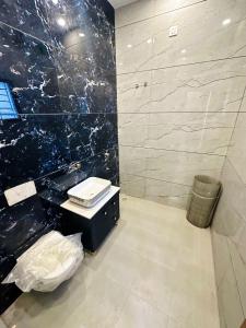 baño con lavabo y pared de mármol negro en Dev HOMESTAY VRINDAVAN, en Vrindāvan 9 fotos más