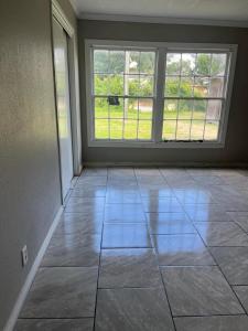 ein leeres Zimmer mit einem großen Fenster und Fliesenboden in der Unterkunft Cozy 2 Bed Retreat in Vibrant Beaumont, TX in Beaumont