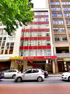 zwei vor einem Gebäude geparkt in der Unterkunft Megaboom City Hotel in Sydney