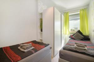 a small bedroom with a bed and yellow curtains at Ferienwohnung Maisonette in Radeberg