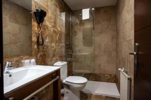a bathroom with a toilet and a sink and a shower at Hotel El Doncel in Sigüenza