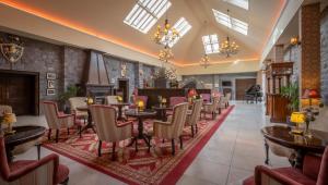 un ristorante con tavoli, sedie e un camino di Kilronan Castle Hotel & Spa a Ballyfarnon