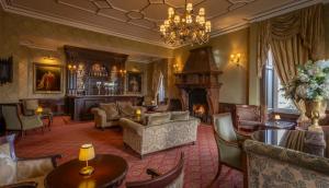 a living room filled with furniture and a fireplace at Kilronan Castle Hotel & Spa in Ballyfarnon