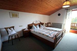 a bedroom with a bed and a chair in it at Haus Klinger in Seebruck