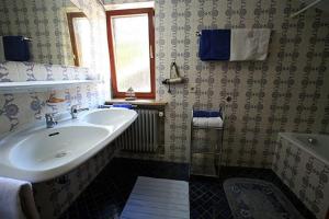 a bathroom with a sink and a tub and a window at Haus Klinger in Seebruck