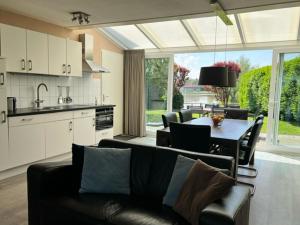 Una sala de estar con un sofá y una mesa y una cocina. en Antibes 236 - Kustpark Village Scaldia, en Hoofdplaat
