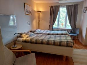 a bedroom with a bed and a couch and a window at Flora Dekor gästgård, Lenagården in Alingsås