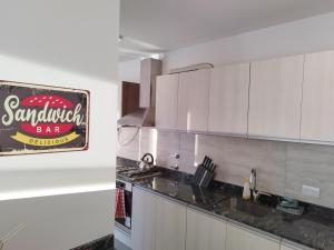 a kitchen with white cabinets and a sign on the wall at Espectacular depto a estrenar TANGO 15 e in Victoria