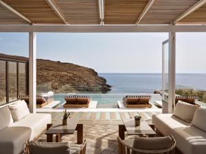 a living room with a view of the ocean at Semeli Coast Mykonos Curio Collection by Hilton in Merchia Beach