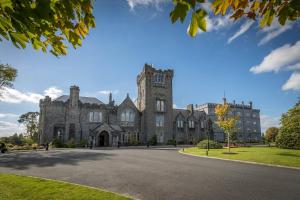 an old castle with a road in front of it at Kilronan Castle Hotel & Spa in Ballyfarnon