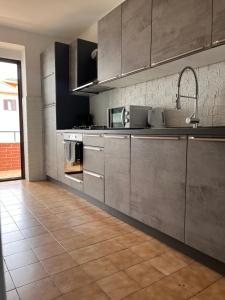a kitchen with stainless steel cabinets and a tile floor at Ikar Apartment in Ika