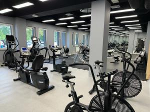 a gym with bikes and treadmills in a room at Baltic Comfort SPA Apartment - FREE swimming pool, saunas & fitness - Kasprowicza 20 in Kołobrzeg