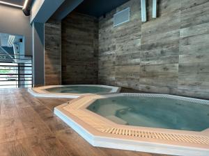 a jacuzzi tub in a room with wooden walls at Baltic Comfort SPA Apartment - FREE swimming pool, saunas & fitness - Kasprowicza 20 in Kołobrzeg