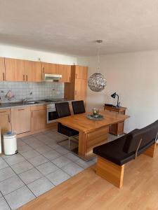 a kitchen with a wooden table and black chairs at Ferienwohnung Frank in Niederalteich