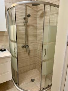 a shower with a glass door in a bathroom at Valencia Gardens Luxurious Studio in Nesebar