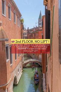 a bridge over a river with a boat under it at Canal View San Marco Luxury Rooms in Venice