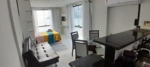 a room with a table and a bedroom with a bed at Loft da Prainha in Arraial do Cabo