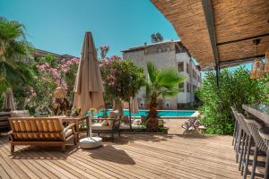 a patio with a table and umbrella and a pool at True Blue Boutique Hotel Kalkan in Kalkan