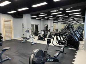 a gym with rows of exercise bikes and treadmills at Baltic Comfort SPA Apartment - FREE swimming pool, saunas & fitness - Kasprowicza 20 in Kołobrzeg