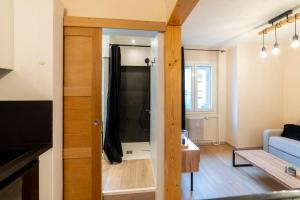 a living room with a shower and a blue couch at La Galleanne studio agréable et chaleureux in Briançon +15 photos