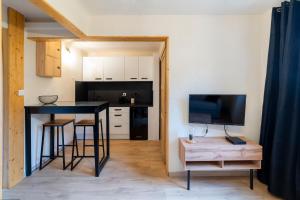 a kitchen with a table and a black counter at La Galleanne studio agréable et chaleureux in Briançon