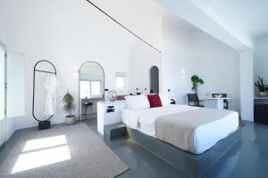 a white bedroom with a large bed and a mirror at Santonero in Akrotiri