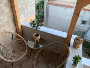 a balcony with two chairs and a table with a plant at House maria elenι in Skala Kallirachis