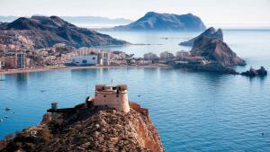 a building on top of a mountain in the water at Casa MARISA in Águilas